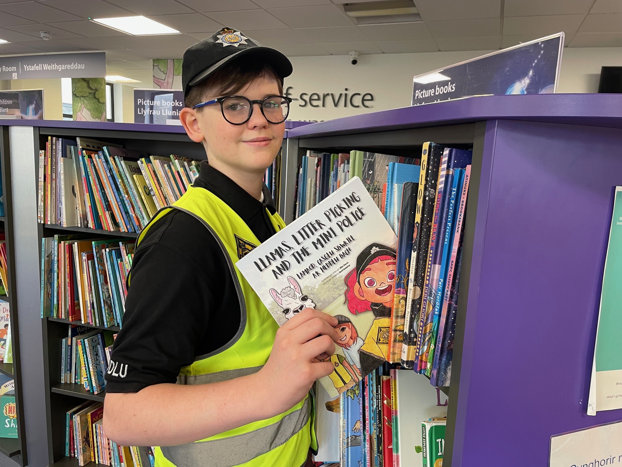 Aelod o lyfr gosod yr heddlu bach ar silff