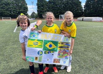 Three pupils from Torfaen holding a poster depicting information about Brazil 