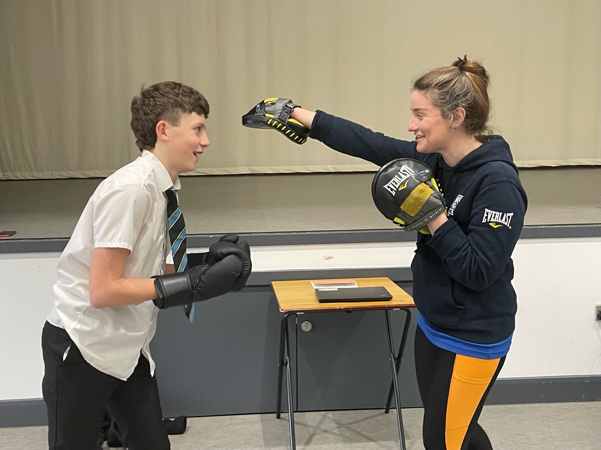 Student boxing with trainer