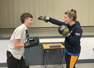 Student boxing with trainer