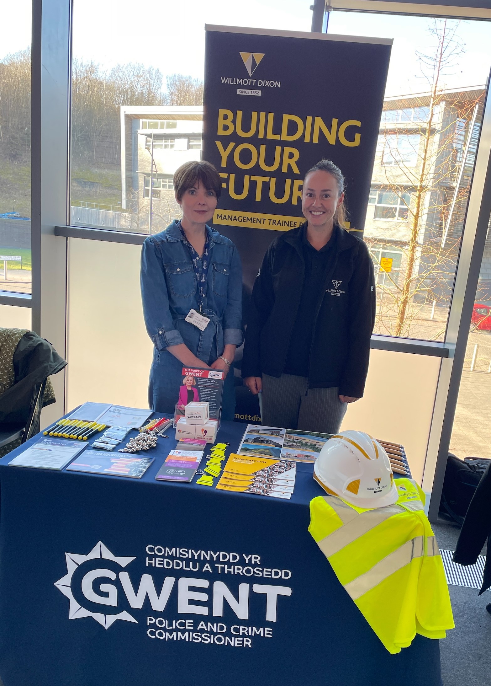 Roedd aelodau'r staff yn sefyll o flaen y faner