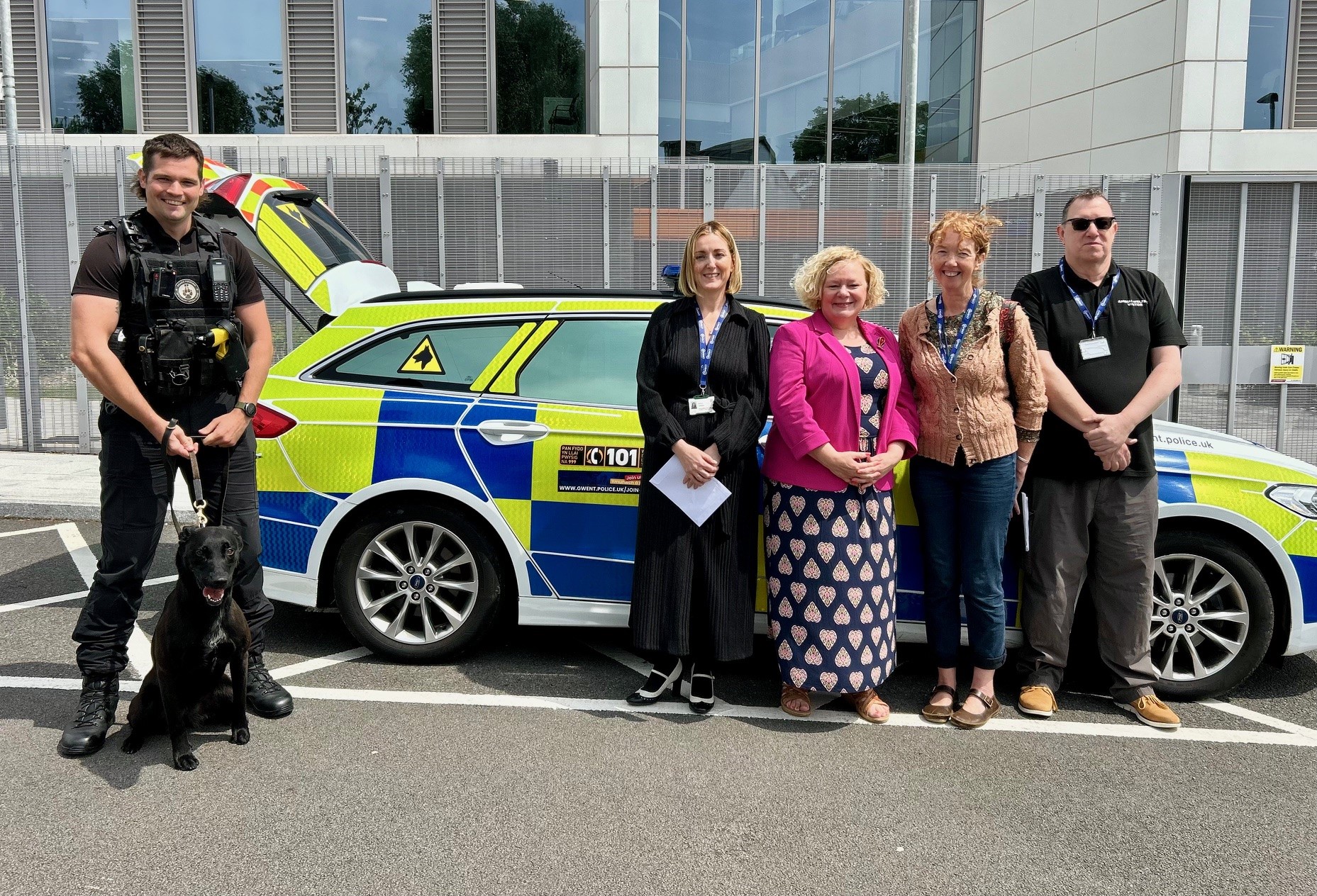 Jane Mudd gyda thrinwr cŵn yr heddlu a gwirfoddolwyr