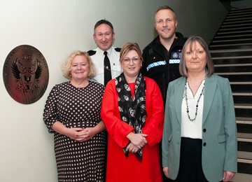 Representatives from partner organisations standing in front of plaque 