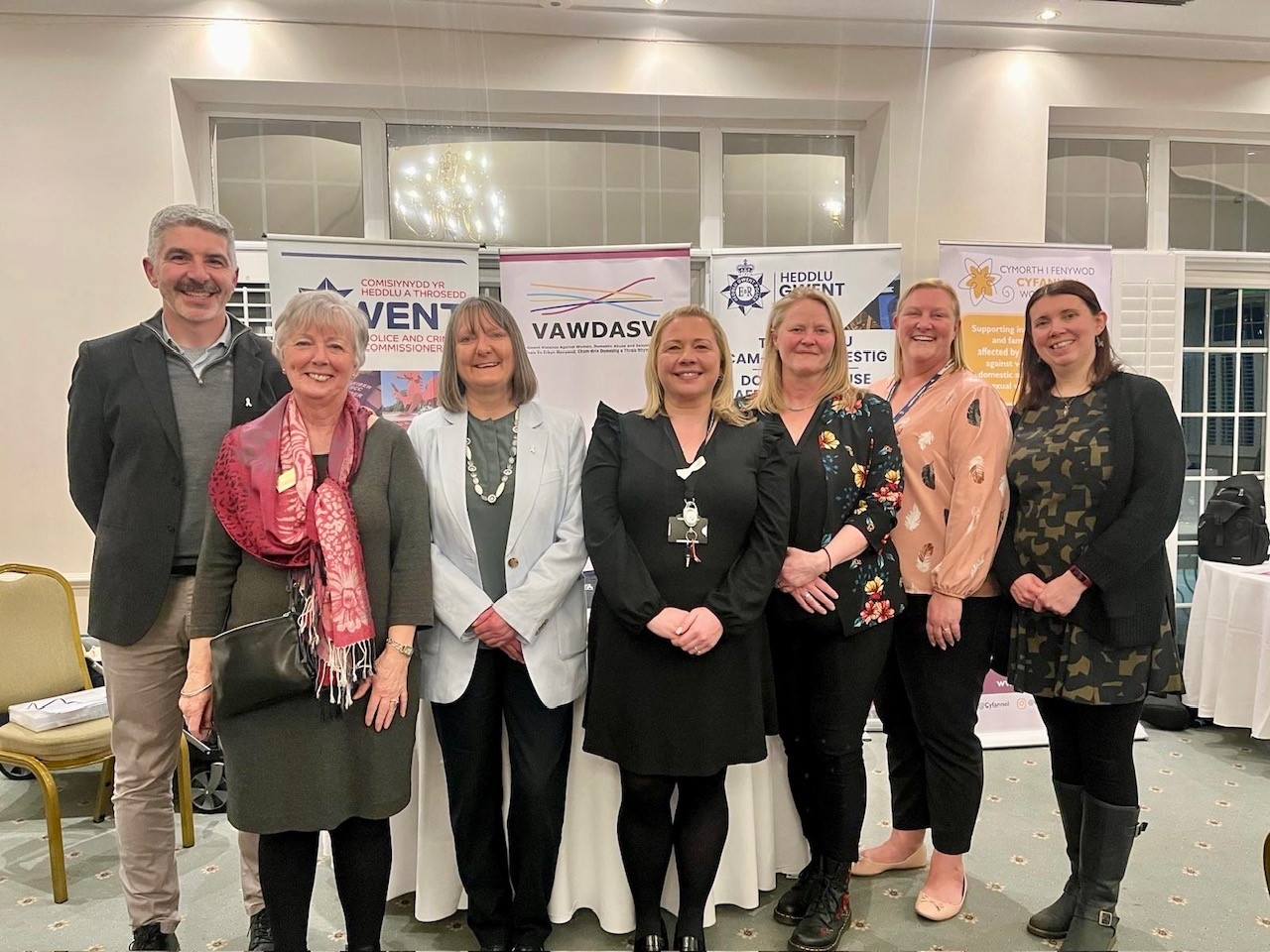Eleri Thomas and partners in front of banners